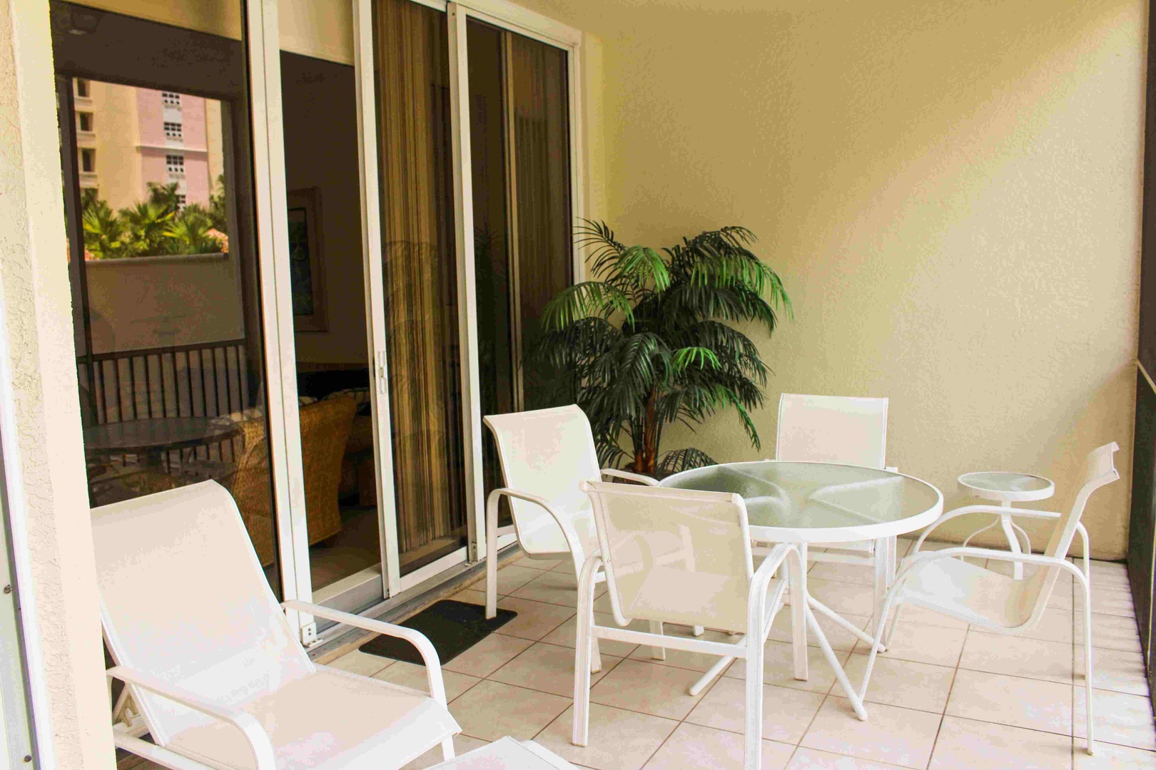 Step onto your private terrace and unwind at the glass-top table, perfect for morning coffee or evening meals in the tropical breeze.