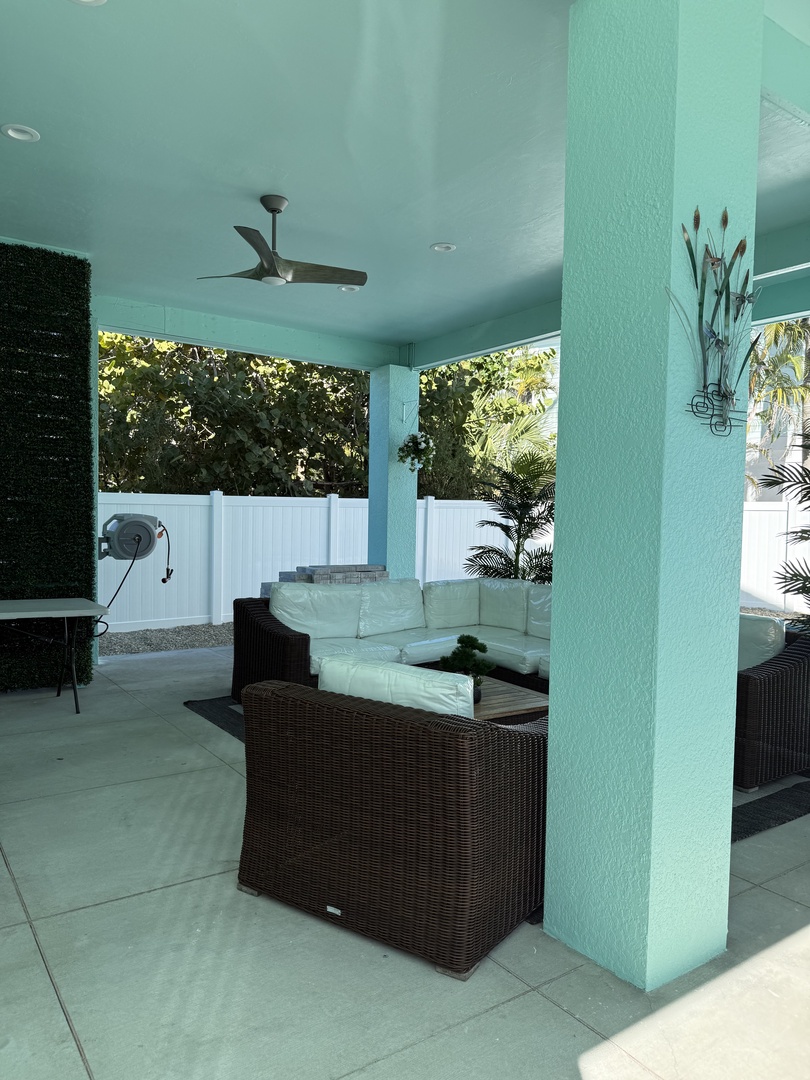 Your private covered terrace offers elegant wicker seating where you can unwind while enjoying tropical garden views.