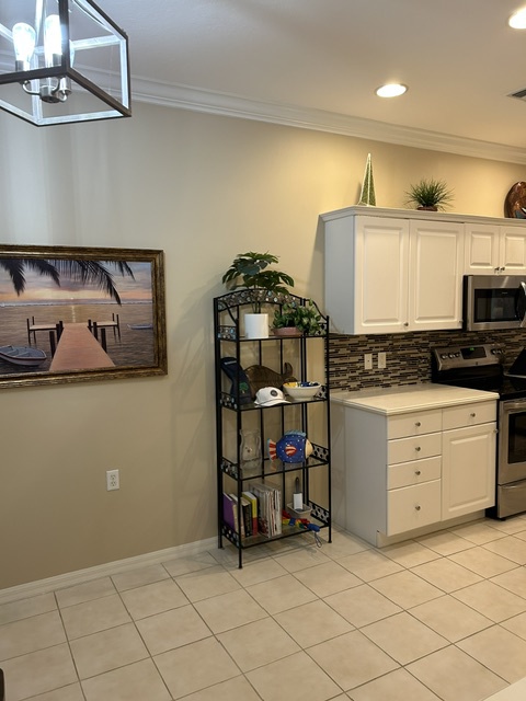 Sleek white cabinetry, modern tile backsplash, and stainless appliances make preparing meals effortless. The open layout and thoughtful storage keep everything you need at your fingertips.