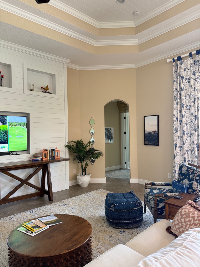 Your spacious living area seamlessly flows between relaxation zones, featuring coastal blue patterns and warm wood accents perfect for unwinding after exploring.