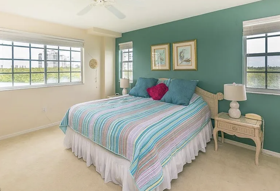 Drift off in this tranquil bedroom featuring soothing coastal colors and serene water views framing your perfect Florida escape.