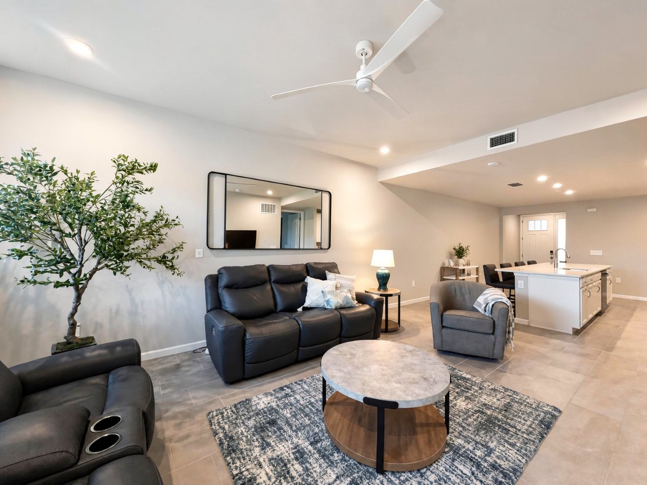 Settle into your spacious living room, where sleek leather seating and a stylish marble coffee table invite you to unwind. The open floor plan flows effortlessly into your dining and kitchen area, creating a bright, airy retreat.