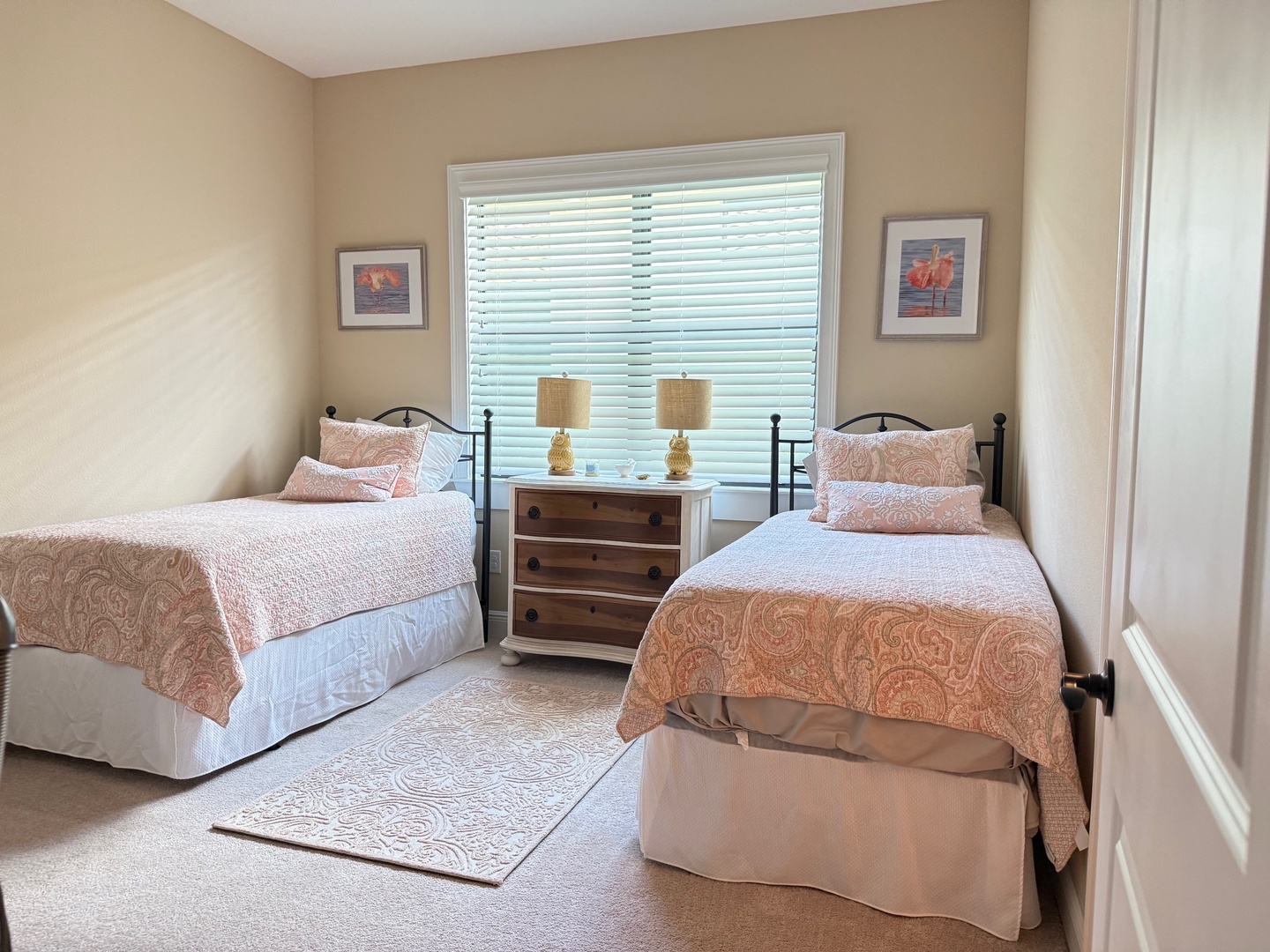 Relax in your peaceful twin bedroom featuring cozy beds with soft linens and warm natural light streaming through the window blinds.