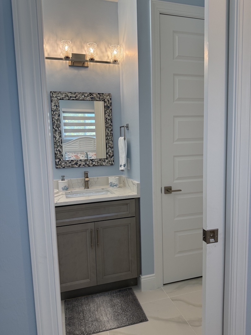Step into your elegant ensuite bathroom featuring a stylish vanity with granite countertops, perfect lighting, and thoughtful storage.