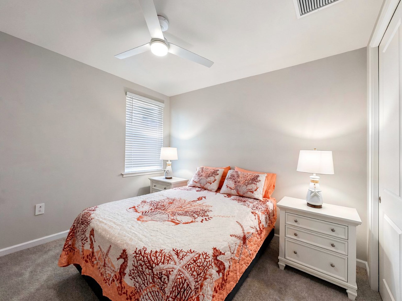 Your peaceful bedroom retreat features a comfortable bed with soft linens and soothing coastal tones. Gentle natural light and a ceiling fan create the perfect environment for restful nights.