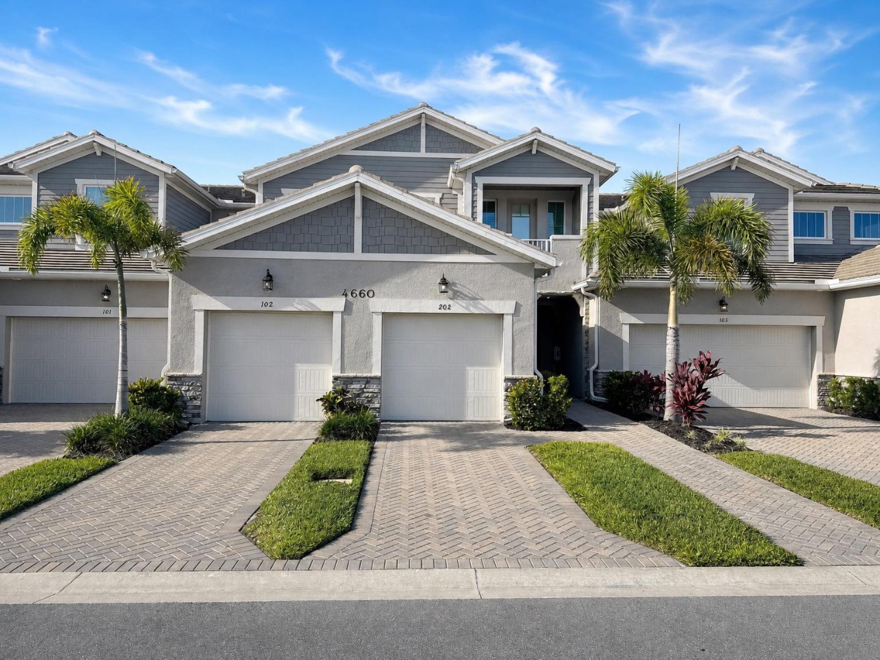 Modern townhome community featuring private garages and tropical landscaping, offering a perfect blend of coastal architecture and Florida-style living.