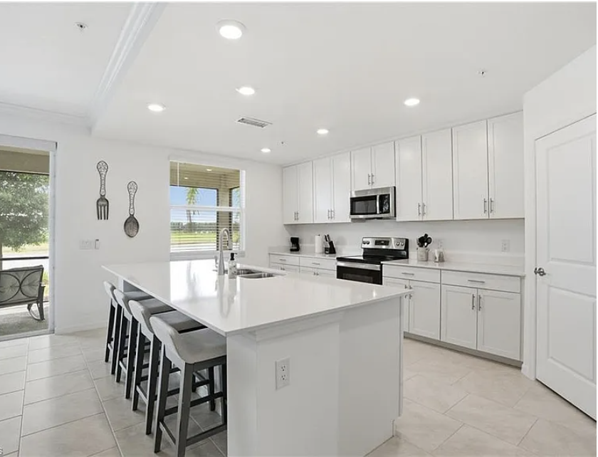 Bright and spacious kitchen with a large island and plenty of counter space, perfect for preparing your favorite meals together.