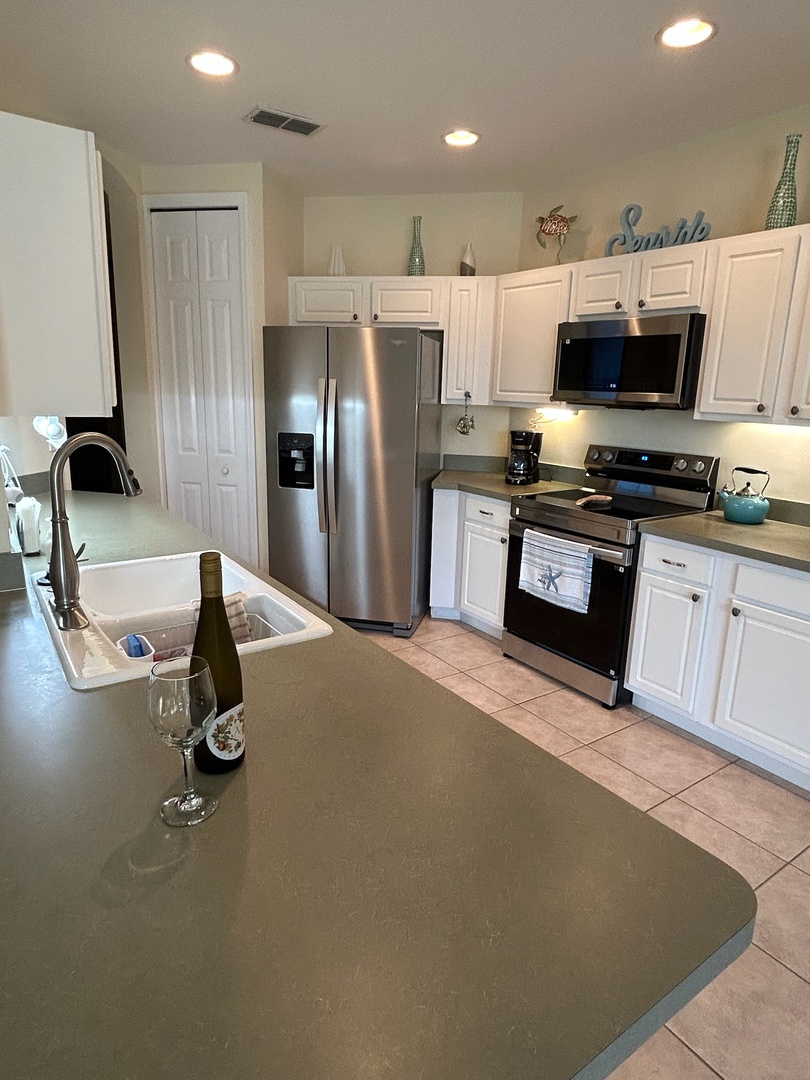 Your modern kitchen features stainless steel appliances and sleek countertops, perfect for preparing meals or enjoying a glass of wine.
