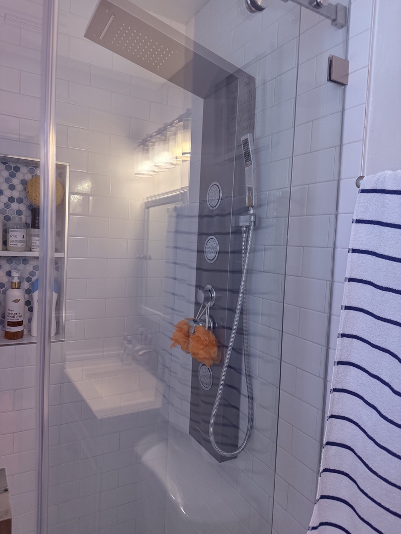 Step into your private spa-like shower with sleek tiling, rainfall showerhead, and handheld option. Fresh towels await, and thoughtful storage keeps your essentials close at hand.