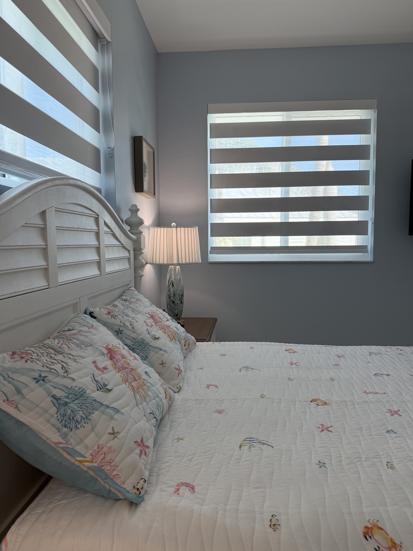 Unwind in this charming ocean-themed bedroom where playful sea life wallpaper and nautical touches create your perfect coastal escape.