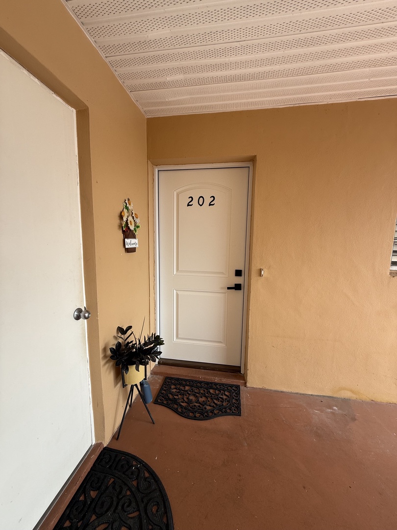 Step into your welcoming room entrance, where thoughtful touches like fresh flowers create a warm, homey atmosphere from the moment you arrive.