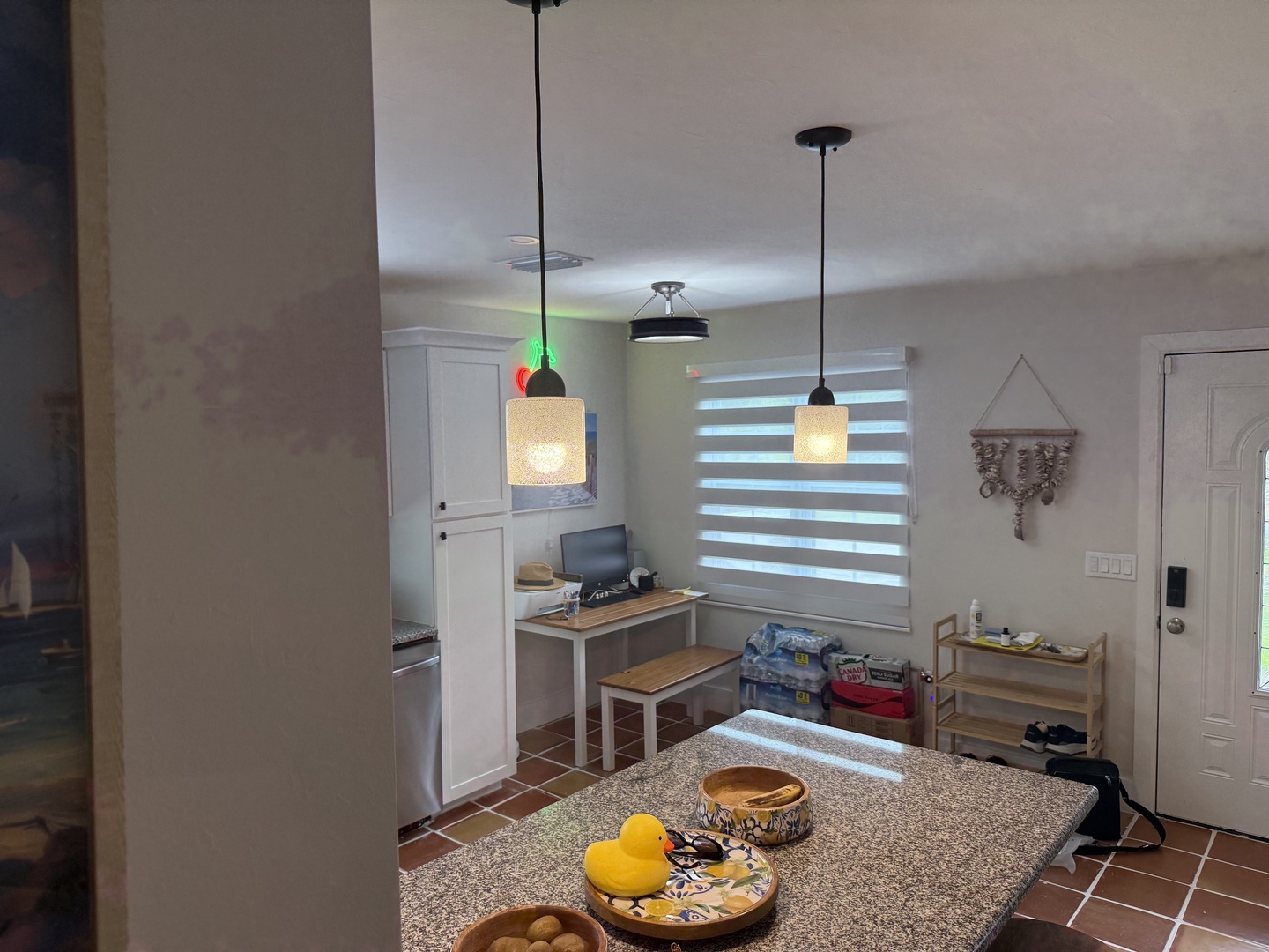 Step into your fully-equipped kitchen with charming pendant lighting and a spacious island perfect for preparing meals or sharing morning coffee together.