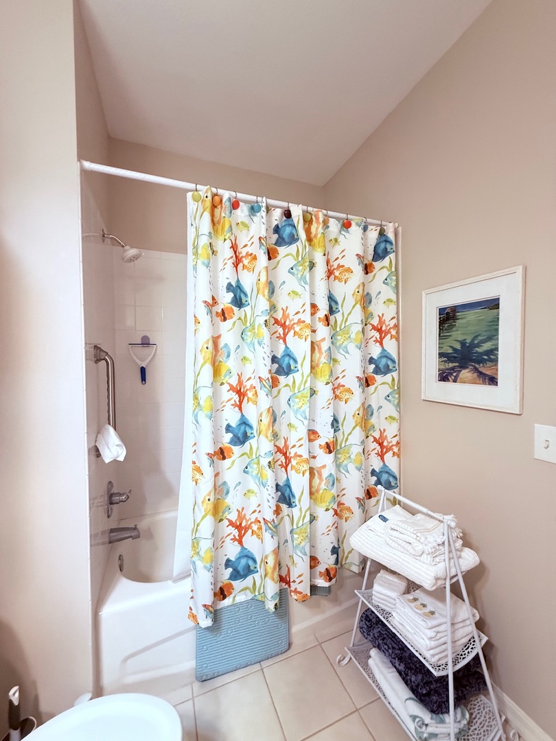 Your private bathroom features a full tub, fresh linens, and thoughtful touches like soft artwork overhead. Everything you need to unwind after a day of exploring.