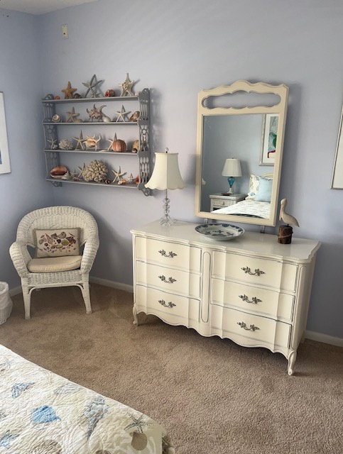 Your peaceful retreat awaits with charming coastal decor and a vintage dresser perfectly placed for your morning routine.