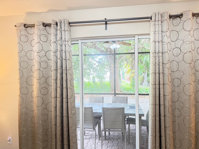 Main bedroom Relax in your bright living space with stylish patterned curtains and scenic garden views through sliding doors to the outdoor dining patio.