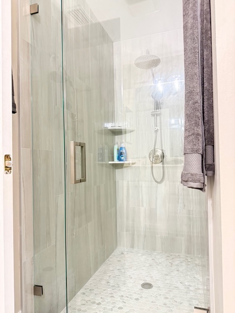 Main bathroom Step into your private glass-enclosed shower with rainfall head and built-in shelving for your toiletries.