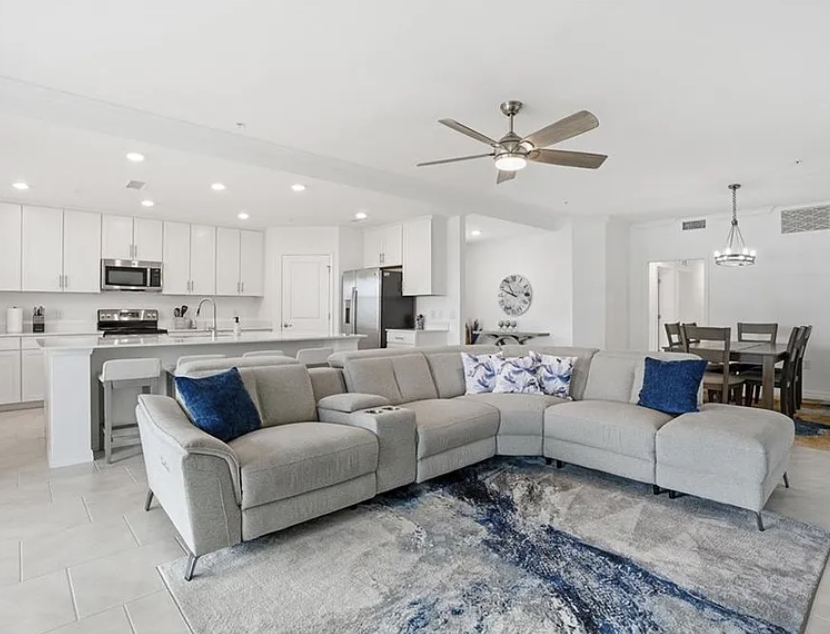 Settle into your spacious open-concept retreat, where a plush sectional sofa invites you to unwind after exploring nearby attractions, while the modern kitchen stands ready for your culinary adventures.