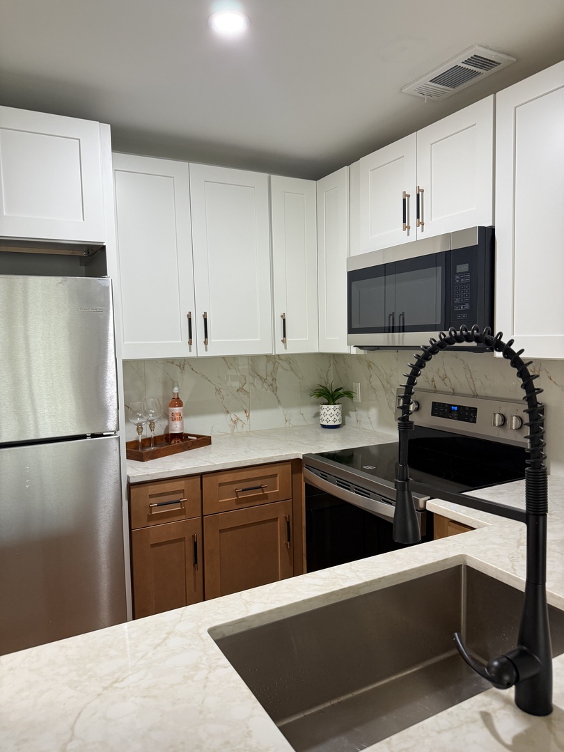 Your modern kitchen features sleek appliances, elegant marble countertops, and stylish pendant lighting perfect for preparing memorable meals together.