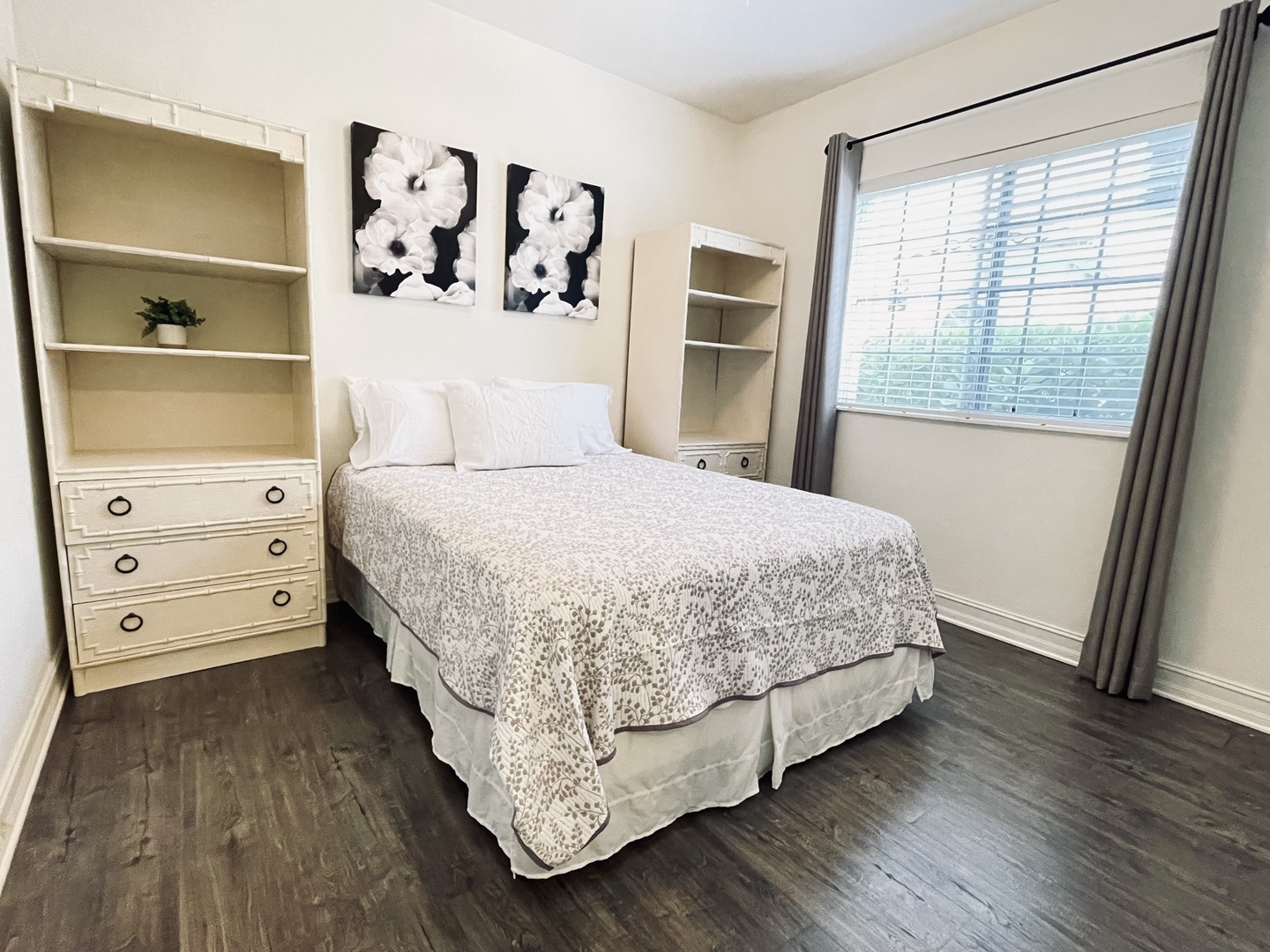 Queen bedroom 2 Relax in your bright bedroom with built-in storage shelves and artwork above the comfortable bed. Natural light streams through windows.