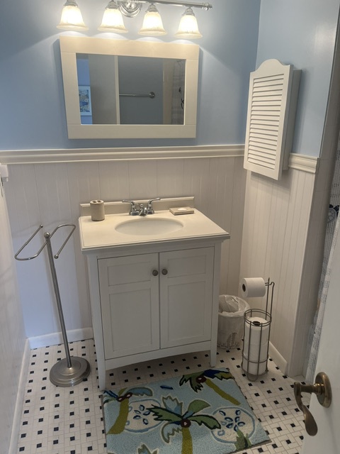 Your private bathroom features classic coastal charm with bright fixtures, a crisp vanity, and elegant tile work—perfect for refreshing after a day of exploring.