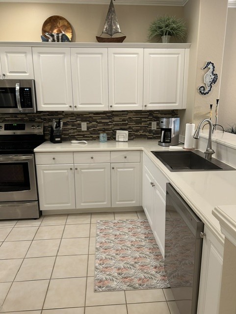 Step into your fully-equipped kitchen with crisp white cabinetry, modern appliances, and a stylish glass tile backsplash. Everything you need to whip up a morning coffee or a seaside-inspired feast is right at your fingertips.