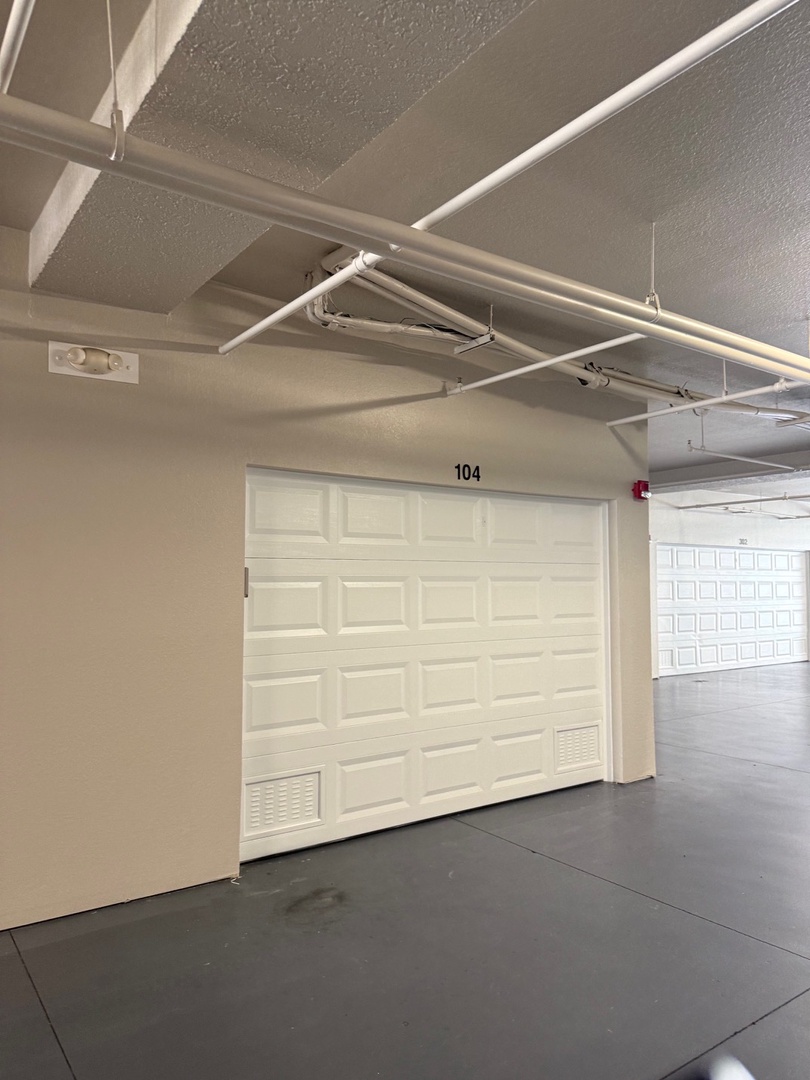 The numbered entrance to your private space, marked with a sleek door labeled 104, awaits your arrival in this modern, minimalist hallway.