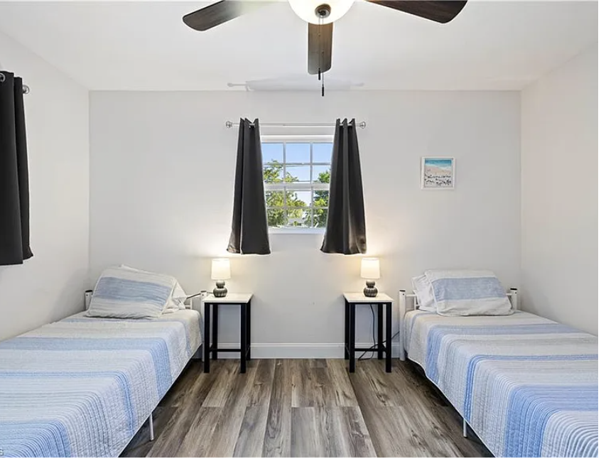 Drift off to sleep in this bright, peaceful bedroom. The ceiling fan keeps things comfortable year-round, while soft lighting and twin beds create a cozy space for rest.