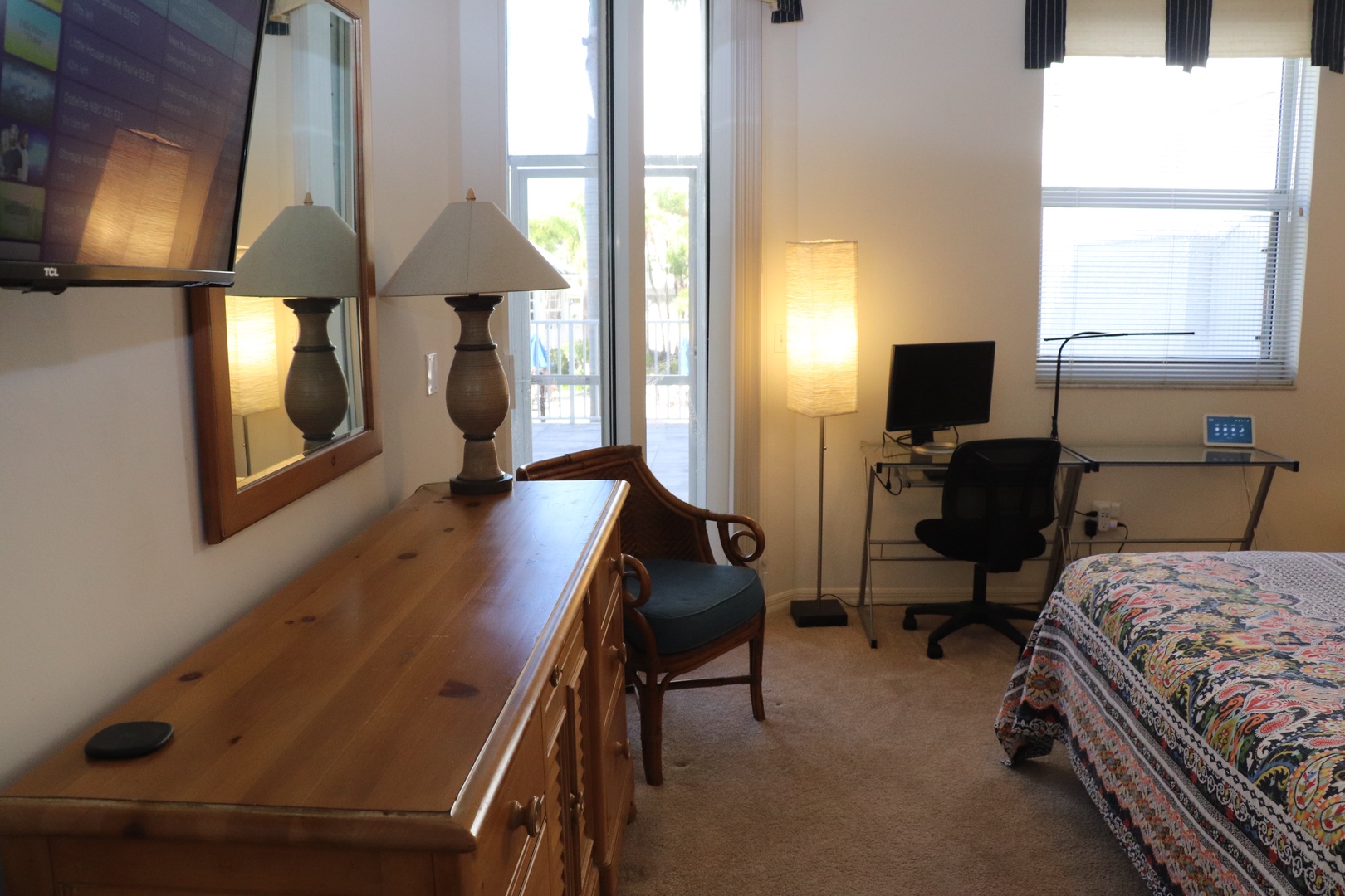 Work comfortably at your dedicated desk with modern computer setup, while natural light streams through large windows.