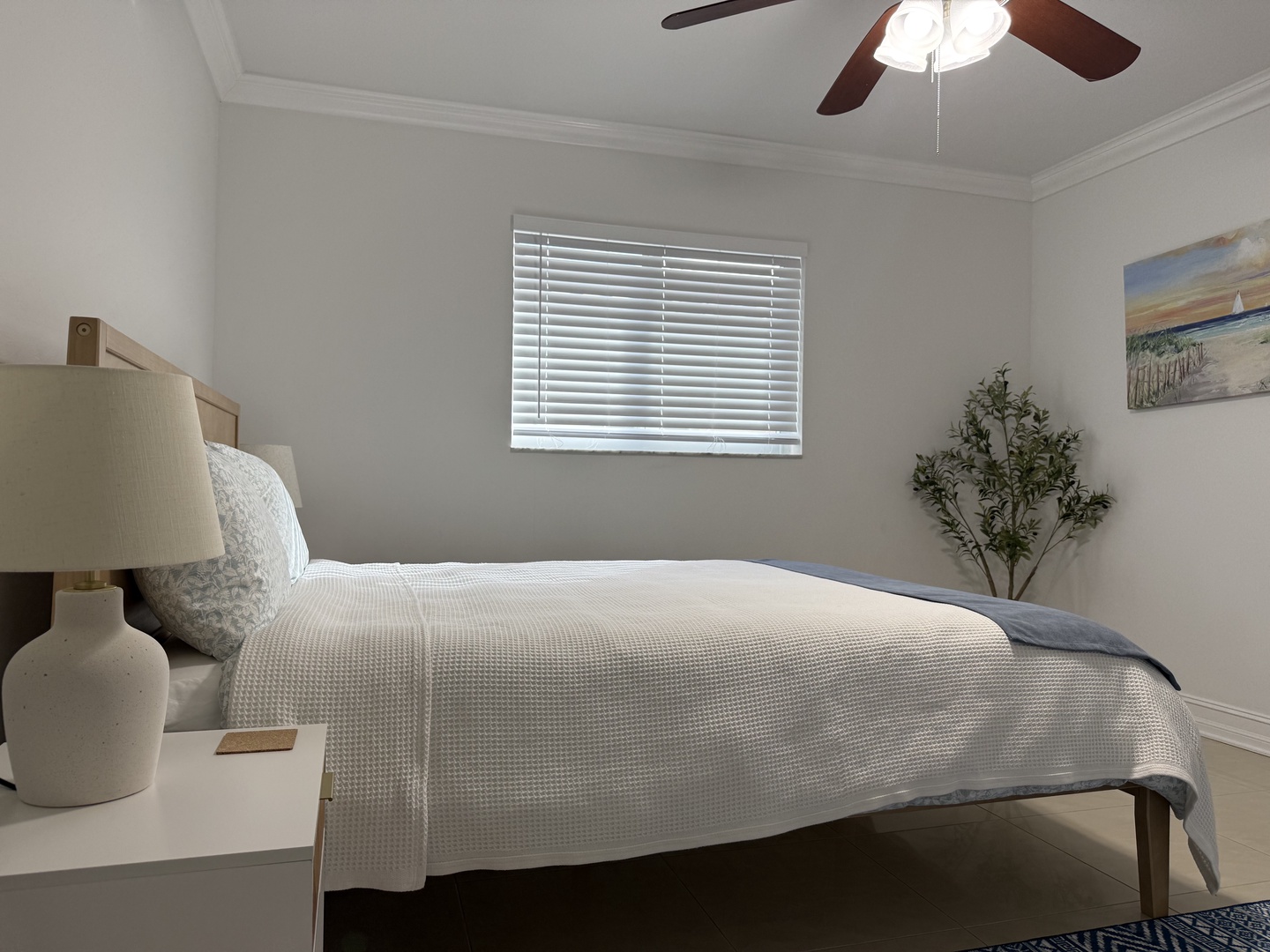 Unwind in your peaceful queen size bedroom sanctuary with soft linens, gentle natural light, and a cooling ceiling fan overhead.