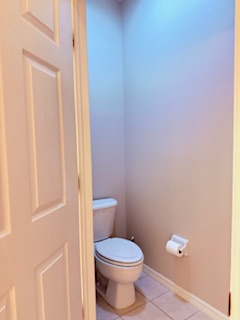 Your private powder room features a modern toilet in a compact, efficiently designed space with soft lighting and clean lines.