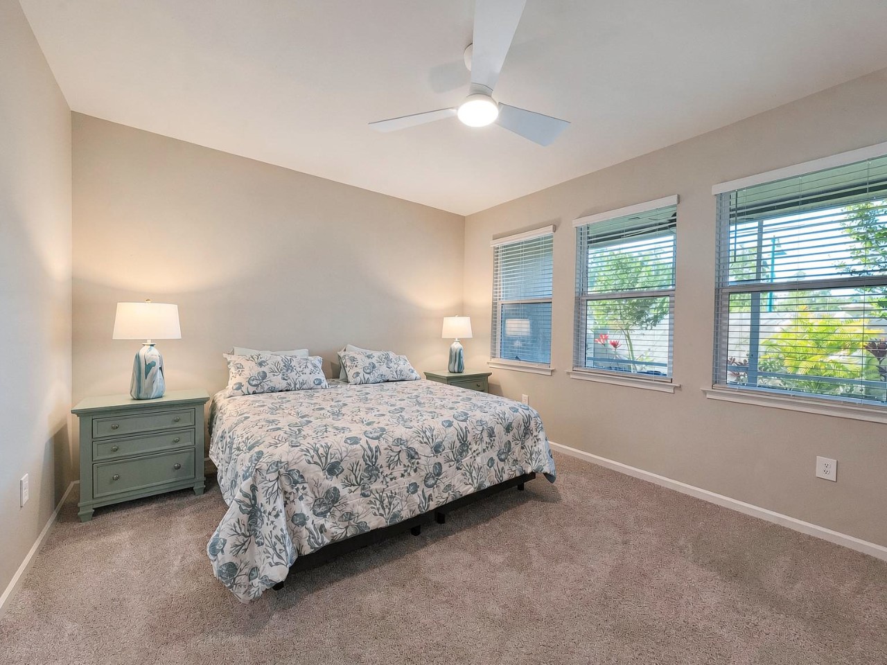 Drift off in this serene bedroom with soft botanical linens, gentle natural light, and a ceiling fan to keep you cool through warm evenings.