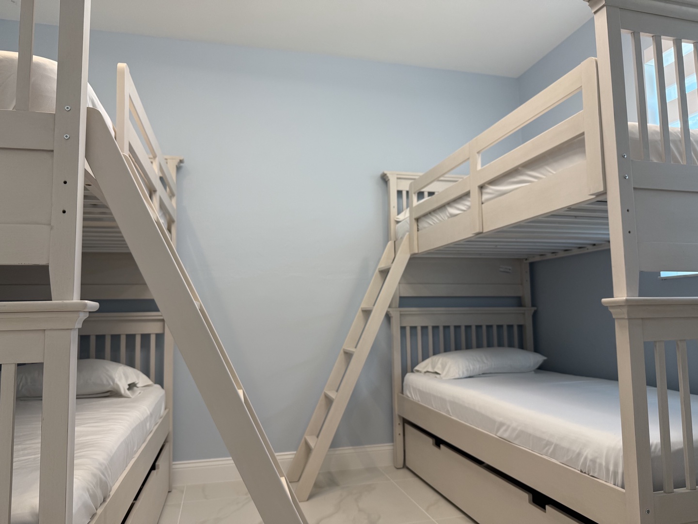 Step into your cozy bunk room where soft blue walls create the perfect space for families to rest together after adventure-filled days.