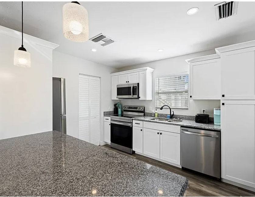Step into your bright, fully equipped kitchen featuring modern appliances, granite countertops, and ample cabinet space—perfect for whipping up meals during your stay.