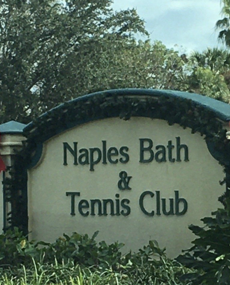 Naples Bath & Tennis Club entrance marker, set amid lush landscaping in a serene Florida neighborhood.