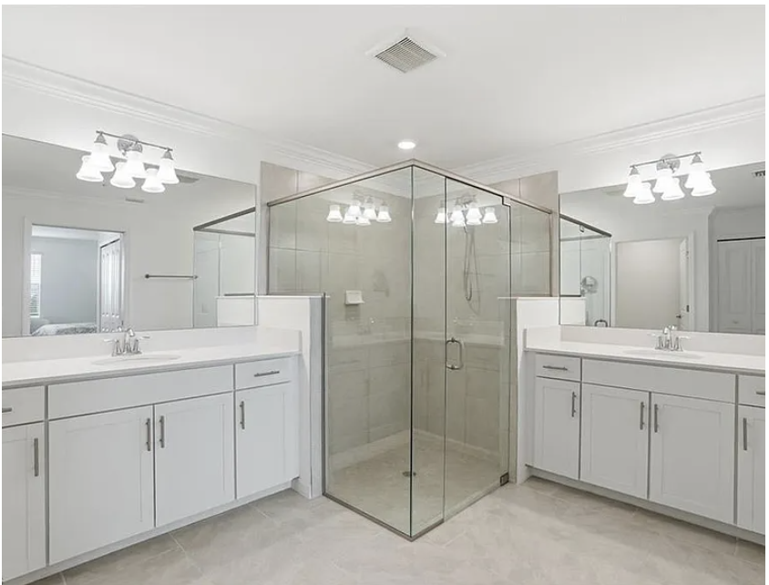 Main bedroom full bathroom spa-like ensuite with dual vanities, gleaming white cabinetry, and a spacious glass-enclosed shower that makes every morning feel luxurious.