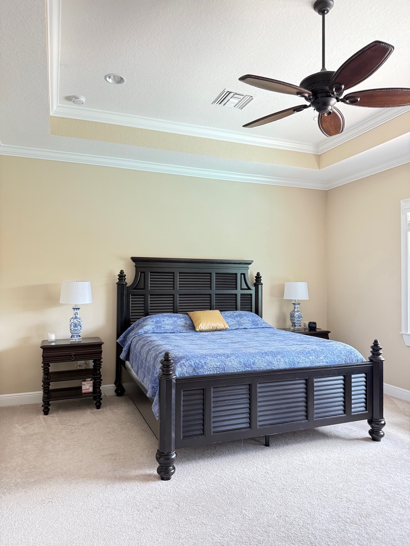 Main bedroom overlooking pool and FL lake Unwind in your bright, airy bedroom featuring a comfortable daybed and ceiling fan for perfect temperature control.