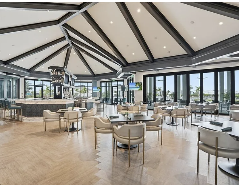 A spacious resort-style lounge area with elegant architecture featuring vaulted ceilings, abundant natural light, and comfortable seating for gathering and relaxation.