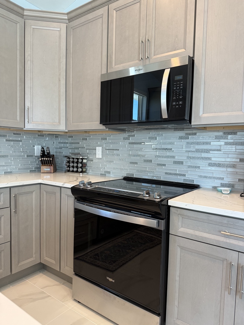 Your sleek kitchen features modern appliances and stylish tile backsplash, perfect for preparing memorable meals during your stay.