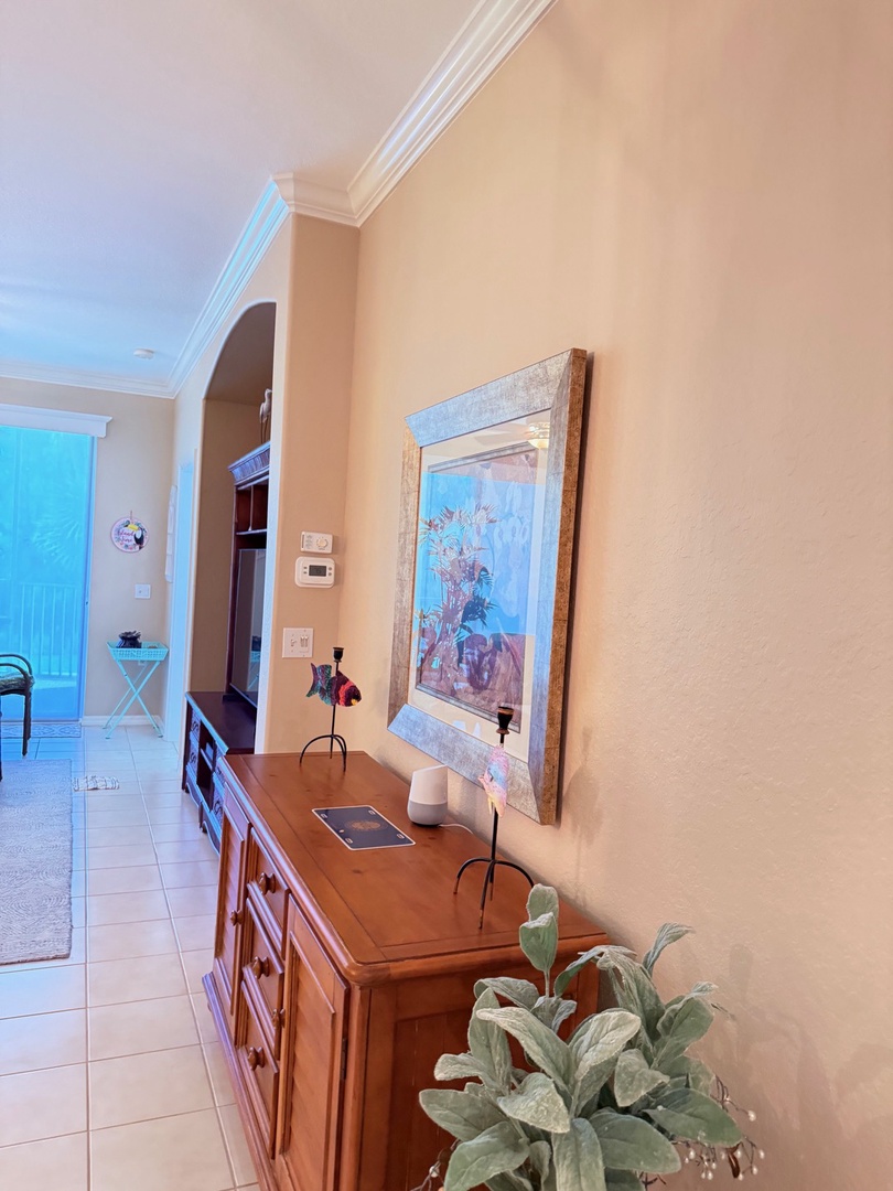 Step into your fully equipped kitchen, complete with a gas stove and warm wood cabinetry. Natural light pours in, while coastal artwork and greenery add a welcoming touch to your cooking space.