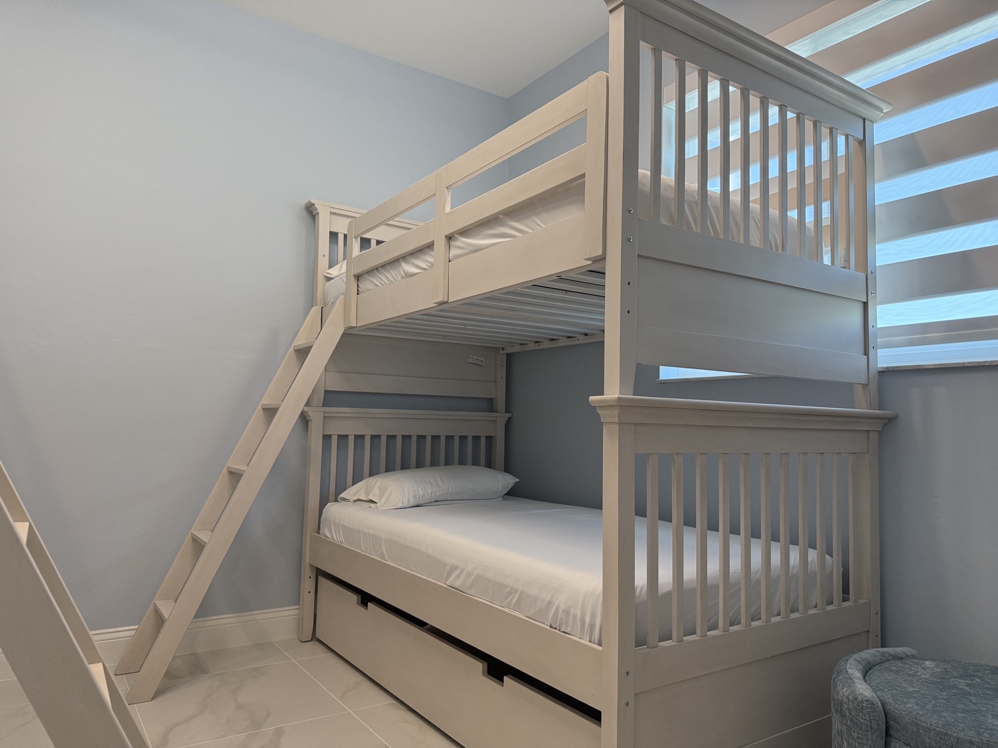 Your family can rest easy in this thoughtfully designed bunk room with crisp white linens and calming coastal colors.