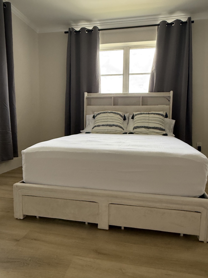 Rest comfortably in your bright bedroom with crisp linens and natural light streaming through the window.