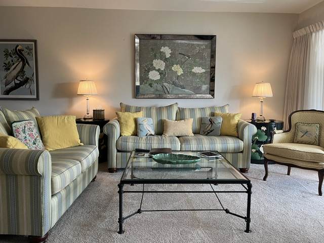 Settle into soft striped seating and unwind in this inviting living room, where warm lamps and cheerful yellow pillows create a cozy retreat after your day of exploring.