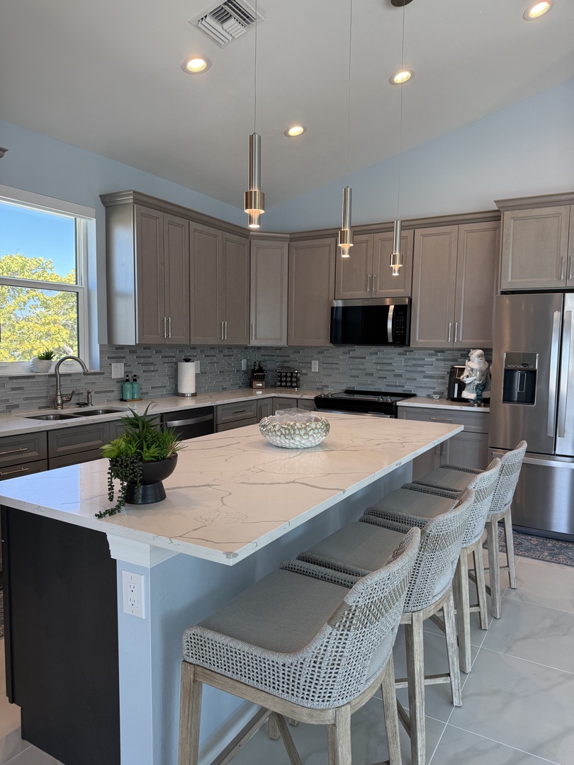 Your modern kitchen features sleek appliances, marble counters, and stylish seating where you'll enjoy cooking and casual meals together.