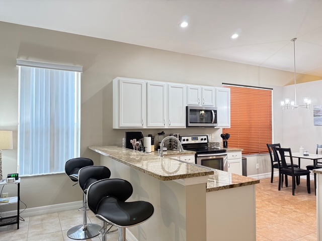 Your spacious kitchen awaits with granite countertops, stainless appliances, and a breakfast bar perfect for morning coffee or casual dining.