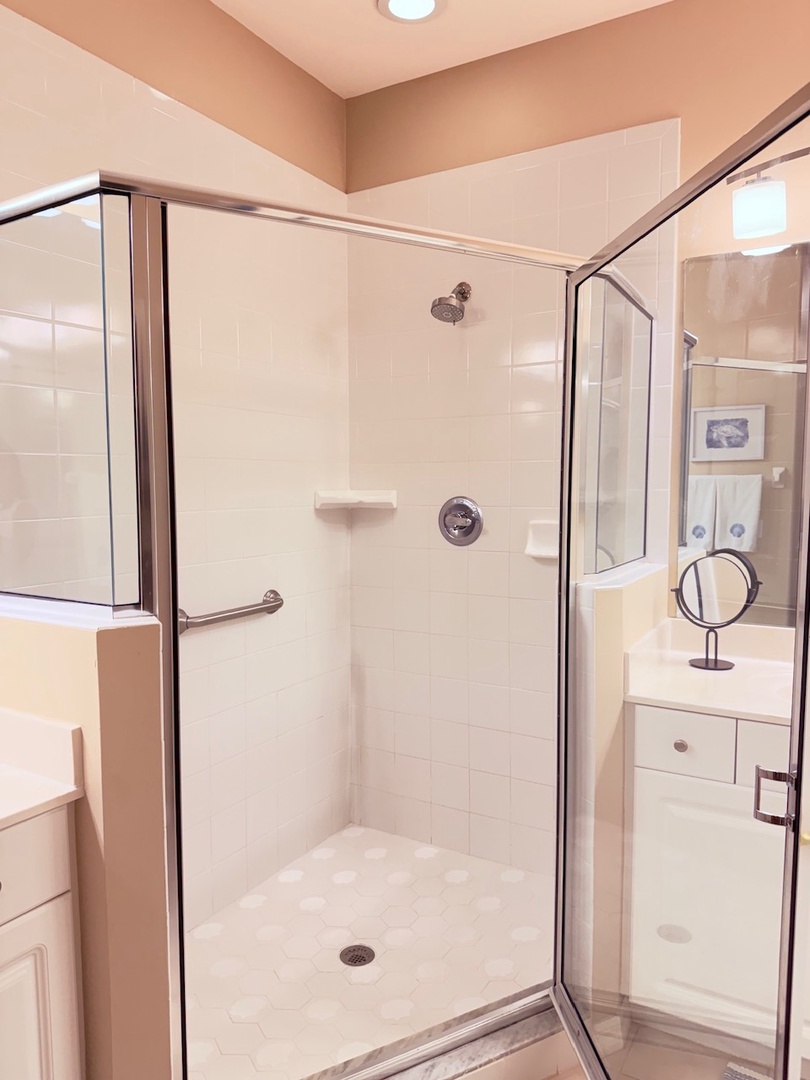 Step into your own refreshing sanctuary with a spacious walk-in shower featuring elegant glass enclosures and crisp white tilework that gleams under warm lighting.