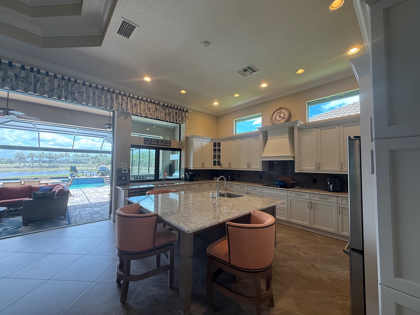 Cook with spectacular views in your gourmet kitchen, featuring granite countertops and modern appliances with pool and water views.