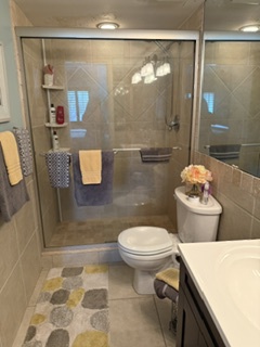 Step into your private spa-like retreat, where sleek glass doors frame a spacious walk-in shower and warm lighting sets the perfect mood for unwinding after your adventures.