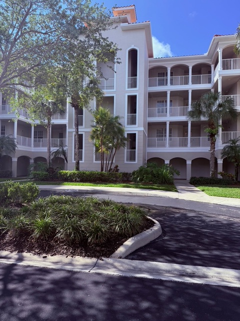 Nestled among manicured gardens and mature tropical trees, this elegant white-washed building welcomes you to a quiet, resort-style community under bright blue skies.