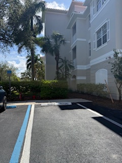 This parking area offers convenient on-site access to the property, surrounded by lush tropical landscaping and palm trees that enhance the South Florida atmosphere.