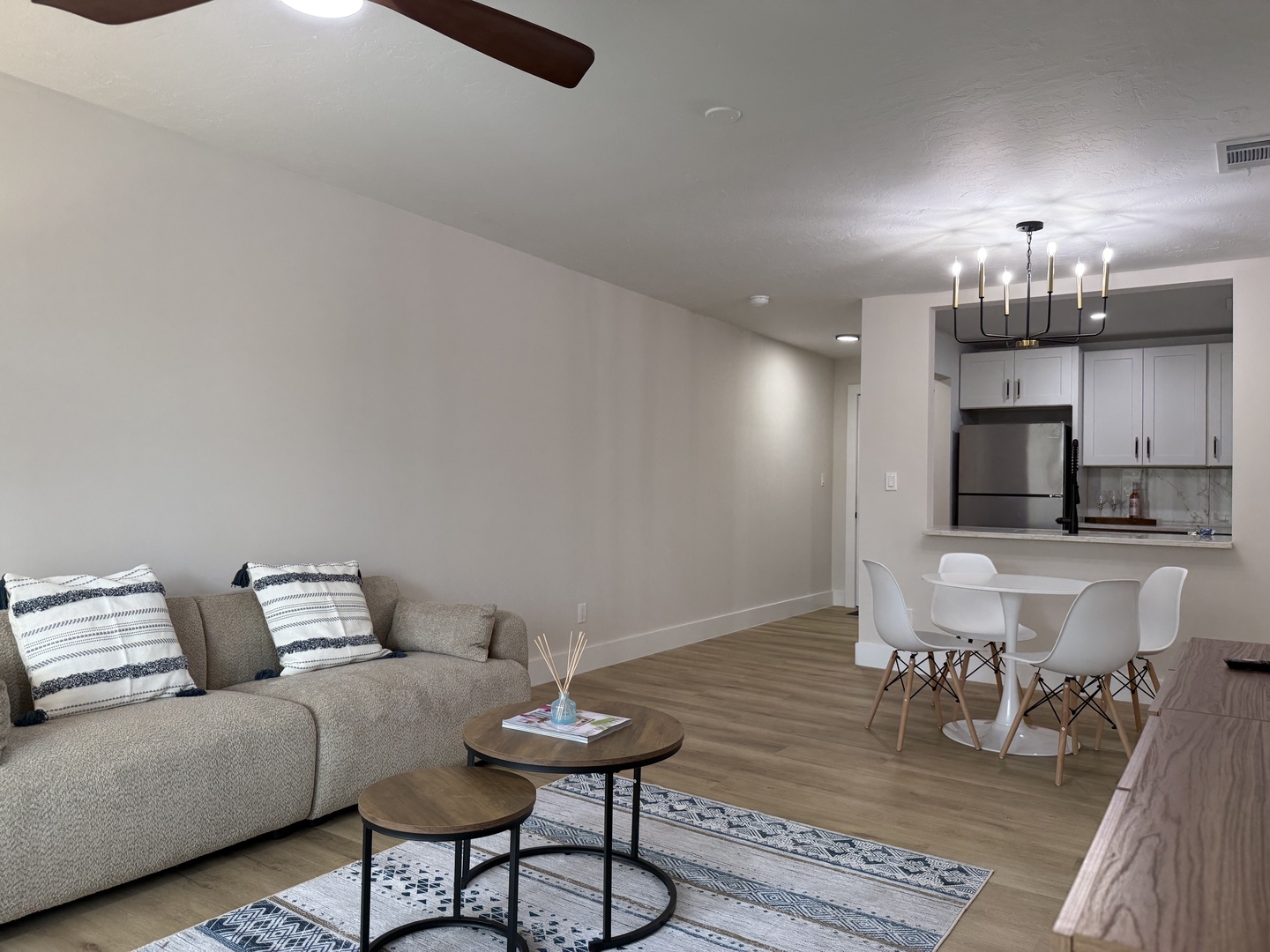 Relax in your modern living space featuring plush seating, elegant hardwood floors, and a fully equipped kitchen perfect for memorable meals.